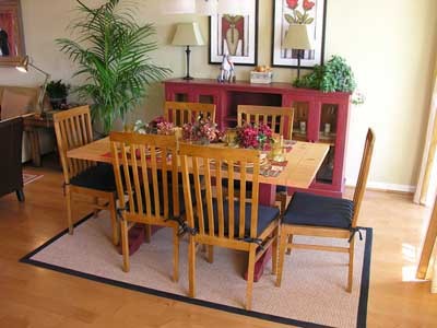 Light-colored furniture and plants create a homey feeling                              around this cozy dining room table.