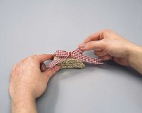 Glue the bow to the front of the bale at the base of ornament.