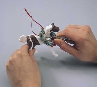 Using tweezers, glue the jingle bells onto the ornament.