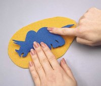 Place the dinosaur and the batting to the yellow felt.