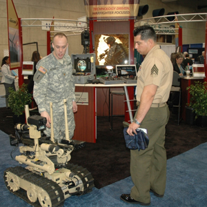 Maj. Michael Pottratz (L), explosive ordnance disposal deputy director of technology for the U.S. Armament Research, Development and Engineering Center, explains the functions of the SWORDS robot at a technology conference in 2008.